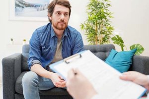 a man talking to a doctor about outpatient opioid addiction treatment program for a loved one