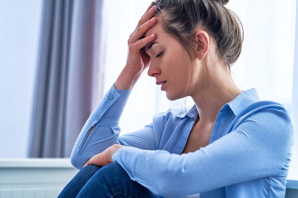 a woman feeling stressed while going through the stages of addiction