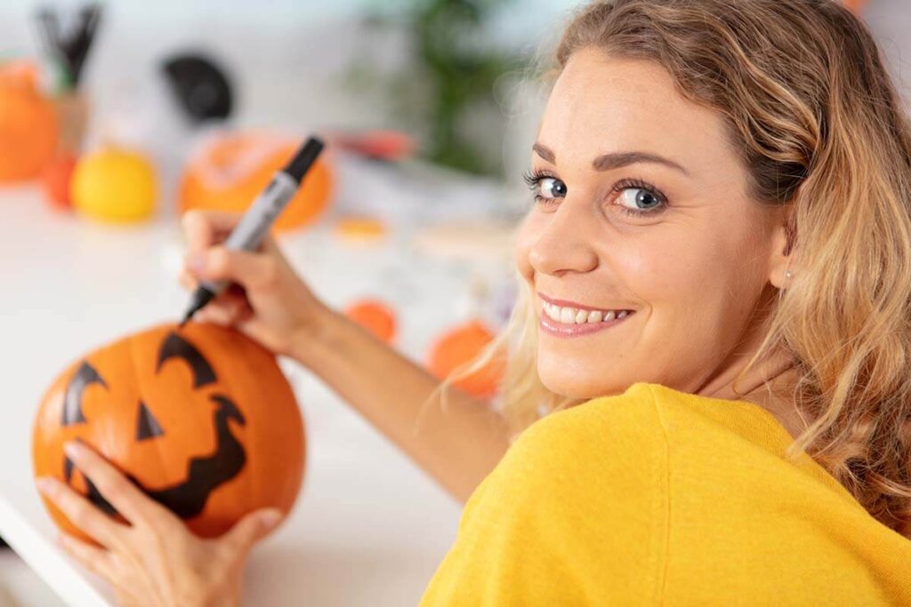 woman painting a pumpkin during Sober October