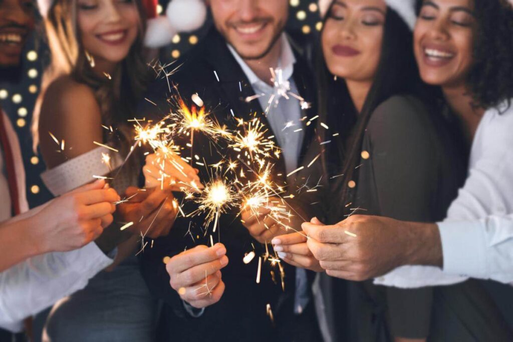 friends with sparklers having sober christmas