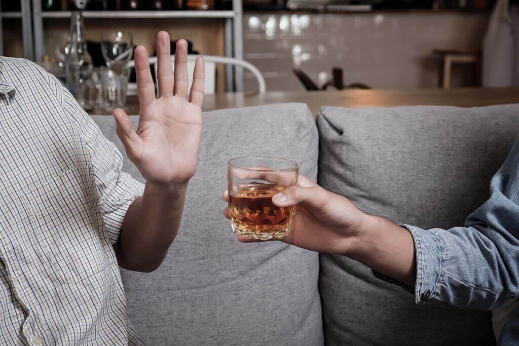 person waving off alcohol trying to quit drinking
