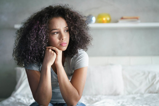 Commonly Abused Opioids in the US woman sitting on bed considering commonly abused opioids