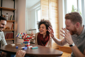 adults laughing and having fun while participating in play therapy
