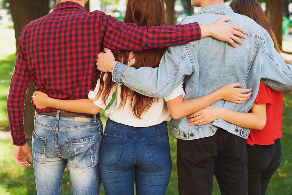 people with arms around each other in a supportive community as one of many benefits of 12 step programs